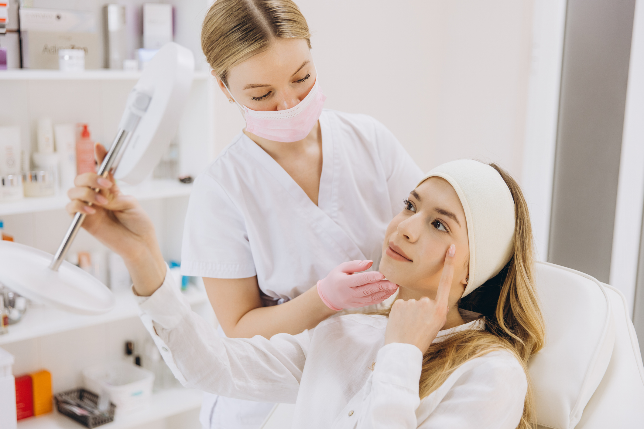 Medical professional displaying botox injection outcome, reflecting patient's transformed appearance with handheld mirror