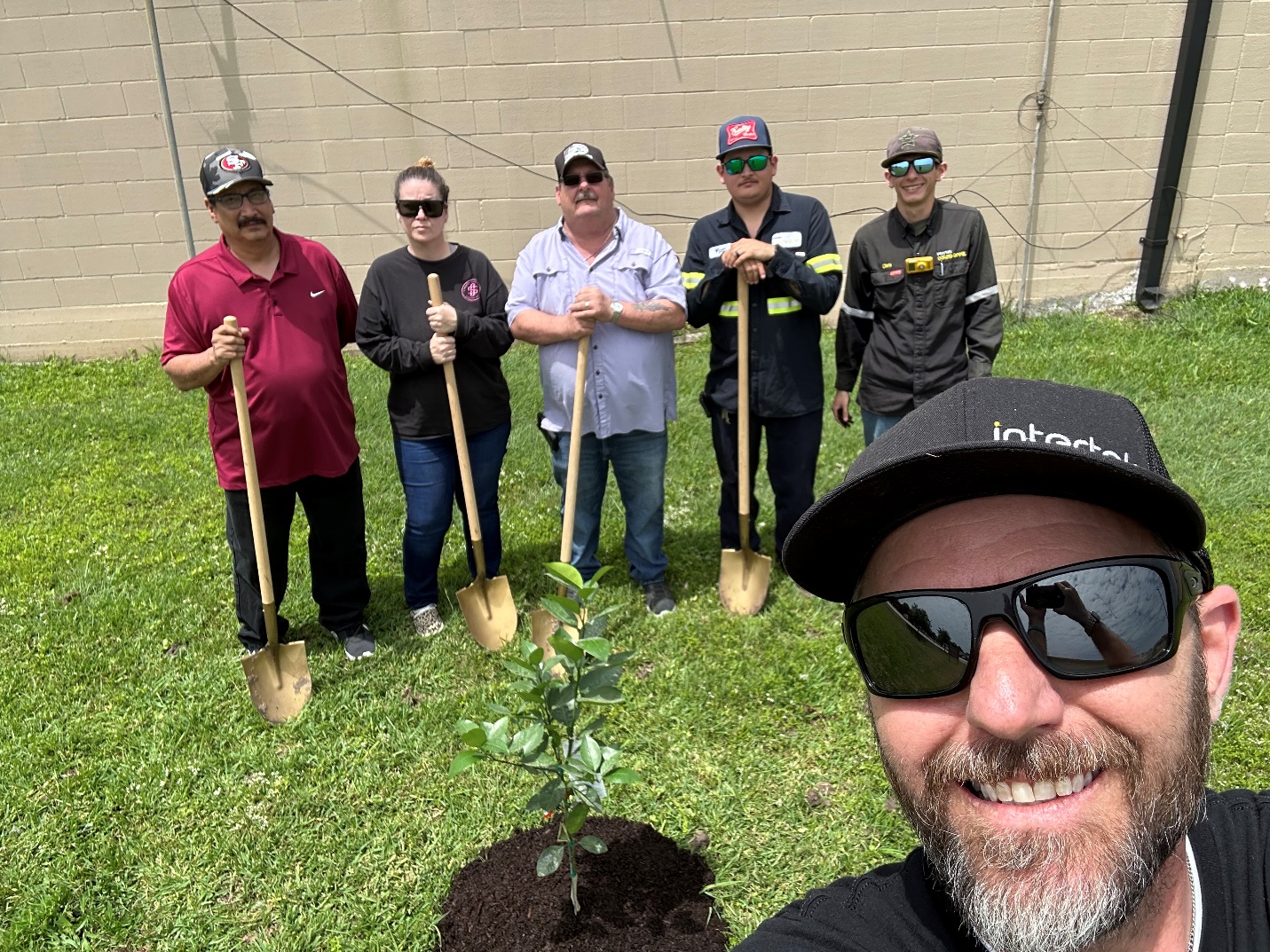 A group of people holding shovels in a yard

Description automatically generated