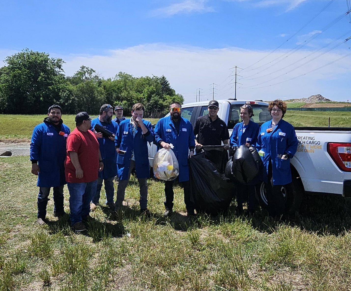 A group of people standing in a field

Description automatically generated