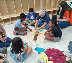 A group of people sitting on the floor

AI-generated content may be incorrect.